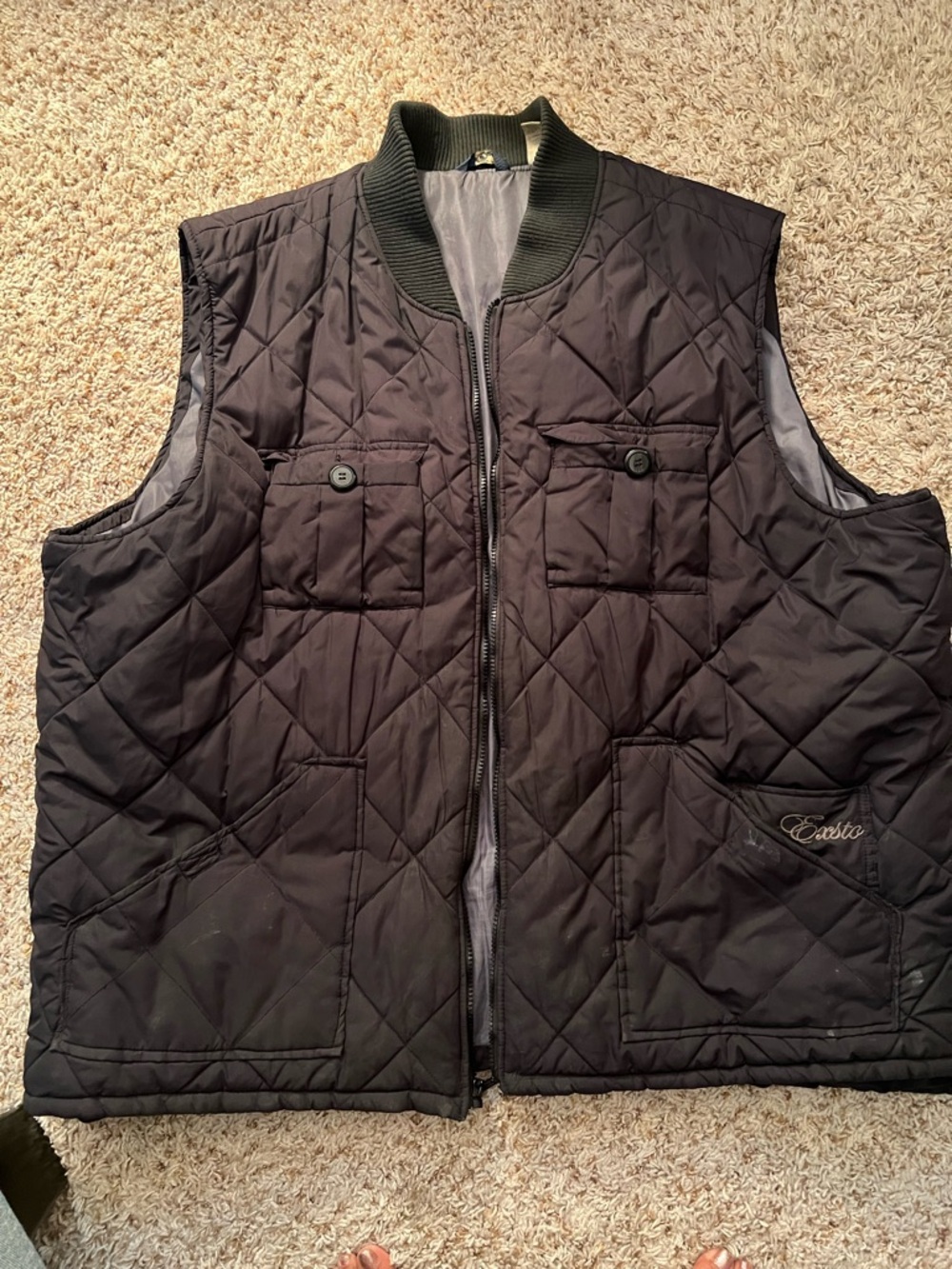 Exsto black quilted vest features a zippered front closure